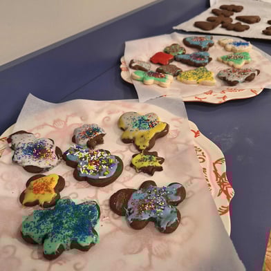 Three plates filled with gingerbread cookies, some of them decorated with colorful icing and sprinkles.